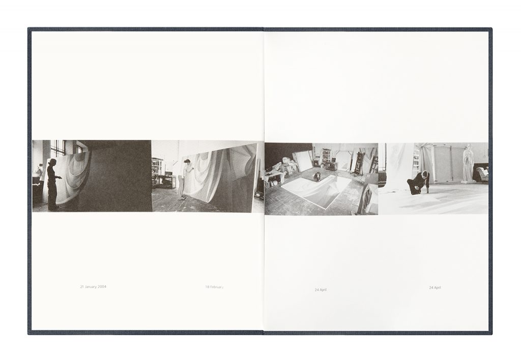 Open book displaying four photographs, all of an artist at work in a studio. The photographs are black and white.