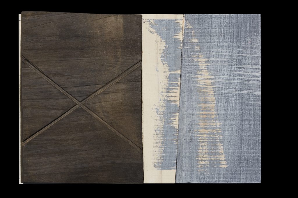 Abstract image featuring paint and sculpture. On the left the image is in dark greys and on the right it is in blue and white