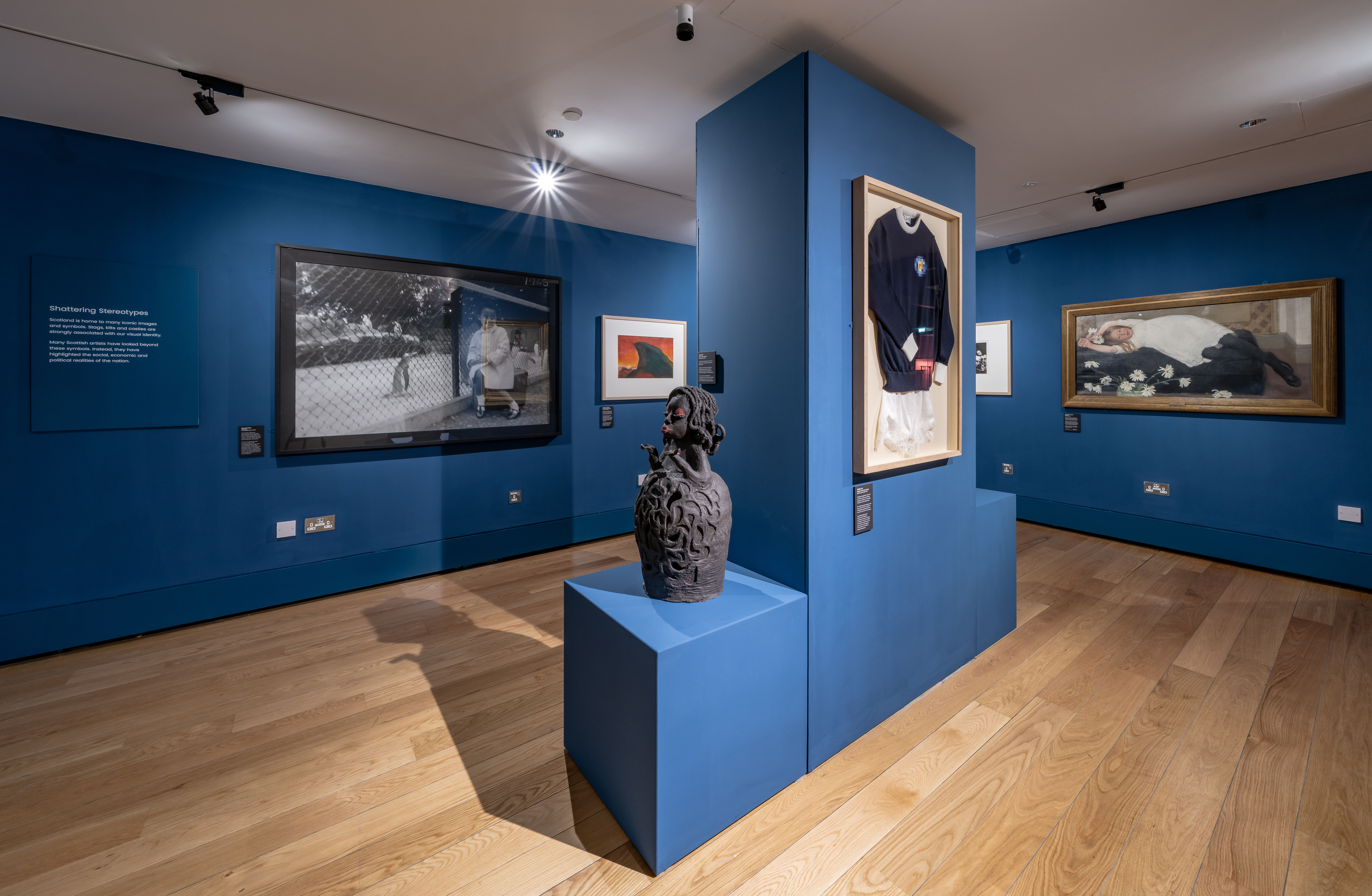 A small sculpture and artworks on blue walls.